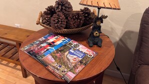 A wooden table with a magazine, a pine cone basket, and a lamp. - Tahoe house with amazing mountain views (South Lake Tahoe)