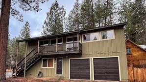 A two-story building with a balcony, a garage, and a staircase leading to the upper level. - Tahoe house with amazing mountain views (South Lake Tahoe)