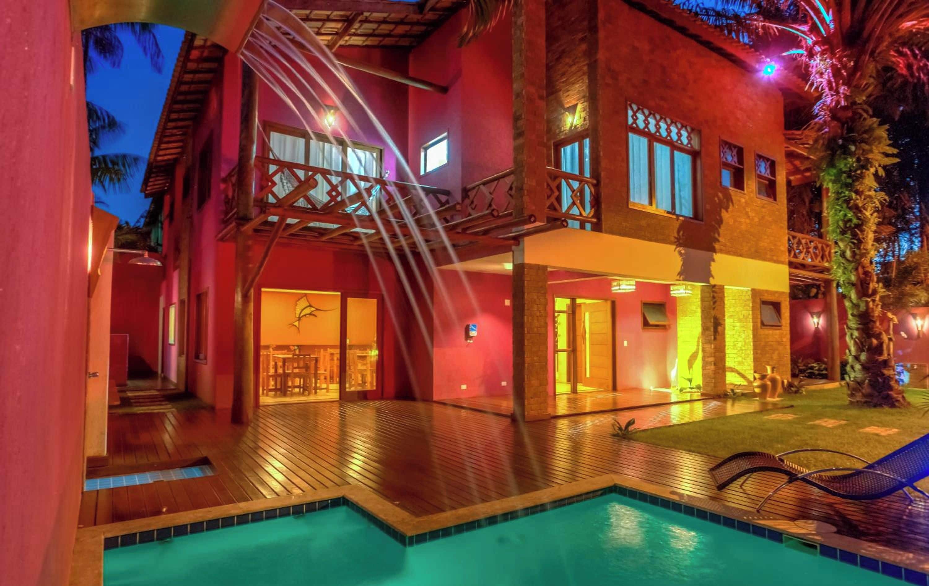 A hotel with a pool, outdoor seating, and a staircase leading to the upper floor.