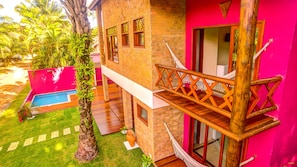 A two-story building with a pool, a hammock, and a wooden balcony. - Raio de Sol Pousada (Itacaré)