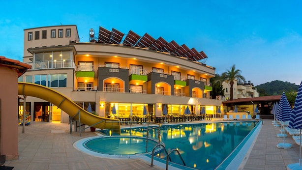 A hotel with a swimming pool, outdoor seating, and a slide. - Rich Melissa Hotel (Kemer)