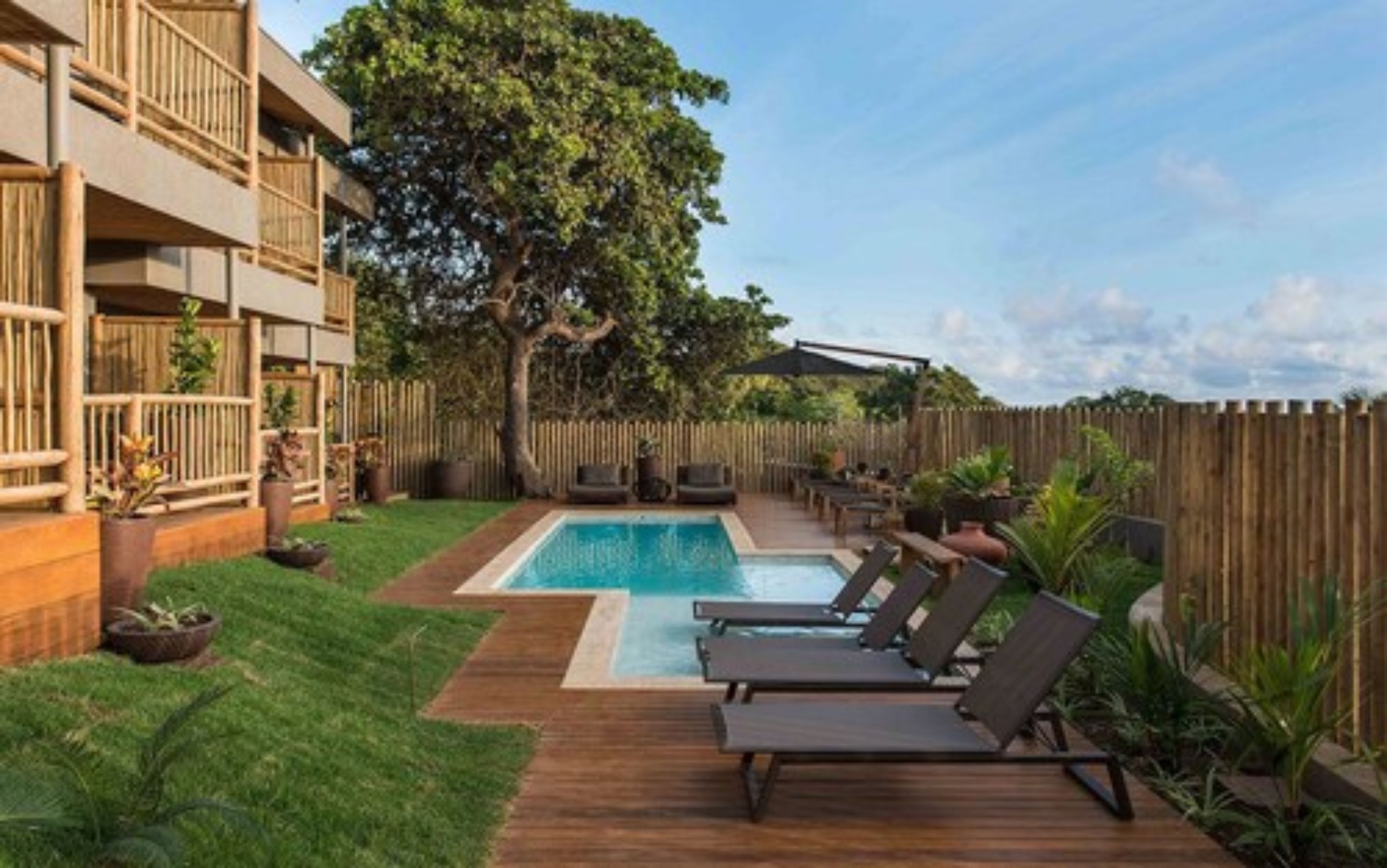A backyard with a swimming pool, lounge chairs, and a wooden deck.