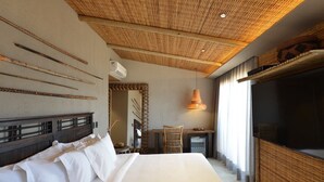 A hotel room with a large bed, a desk with a chair, a TV, and a ceiling with a woven design. - Pousada Maria Bonita Noronha (Fernando de Noronha)