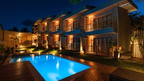 A modern hotel with a swimming pool, multiple balconies, and outdoor lighting. - Pousada Maria Bonita Noronha (Fernando de Noronha)