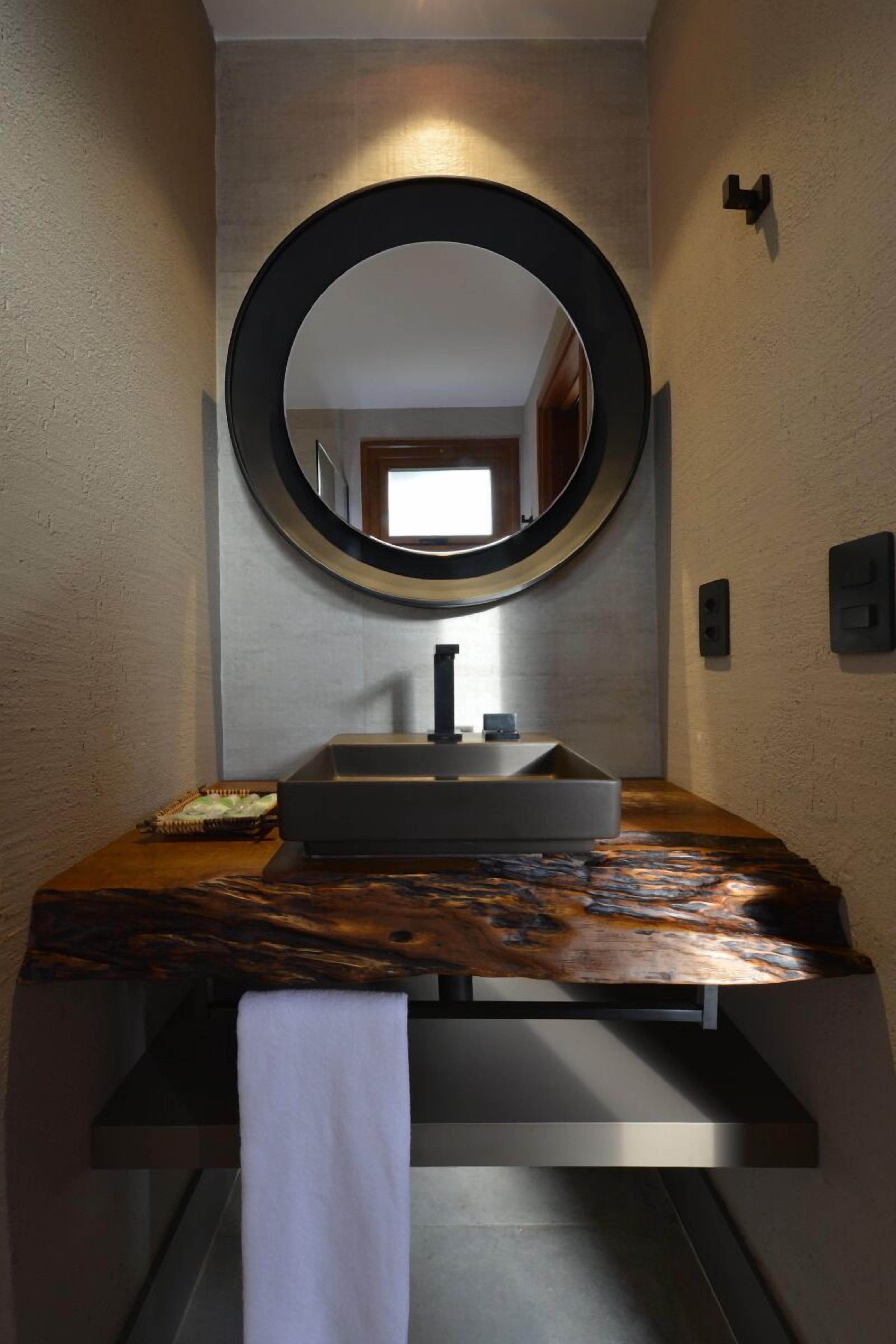 A bathroom with a large mirror, a modern sink, and a towel rack.
