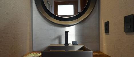 A bathroom with a large mirror, a modern sink, and a towel rack.