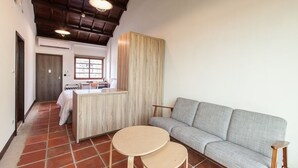 A compact living space with a kitchenette, a sofa, and two small tables. - Penghu Bay Resort (Magong)
