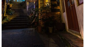 A narrow alleyway with a staircase leading to a building with a sign that reads "Hotel". - Qi Tang Lane (New Taipei City)