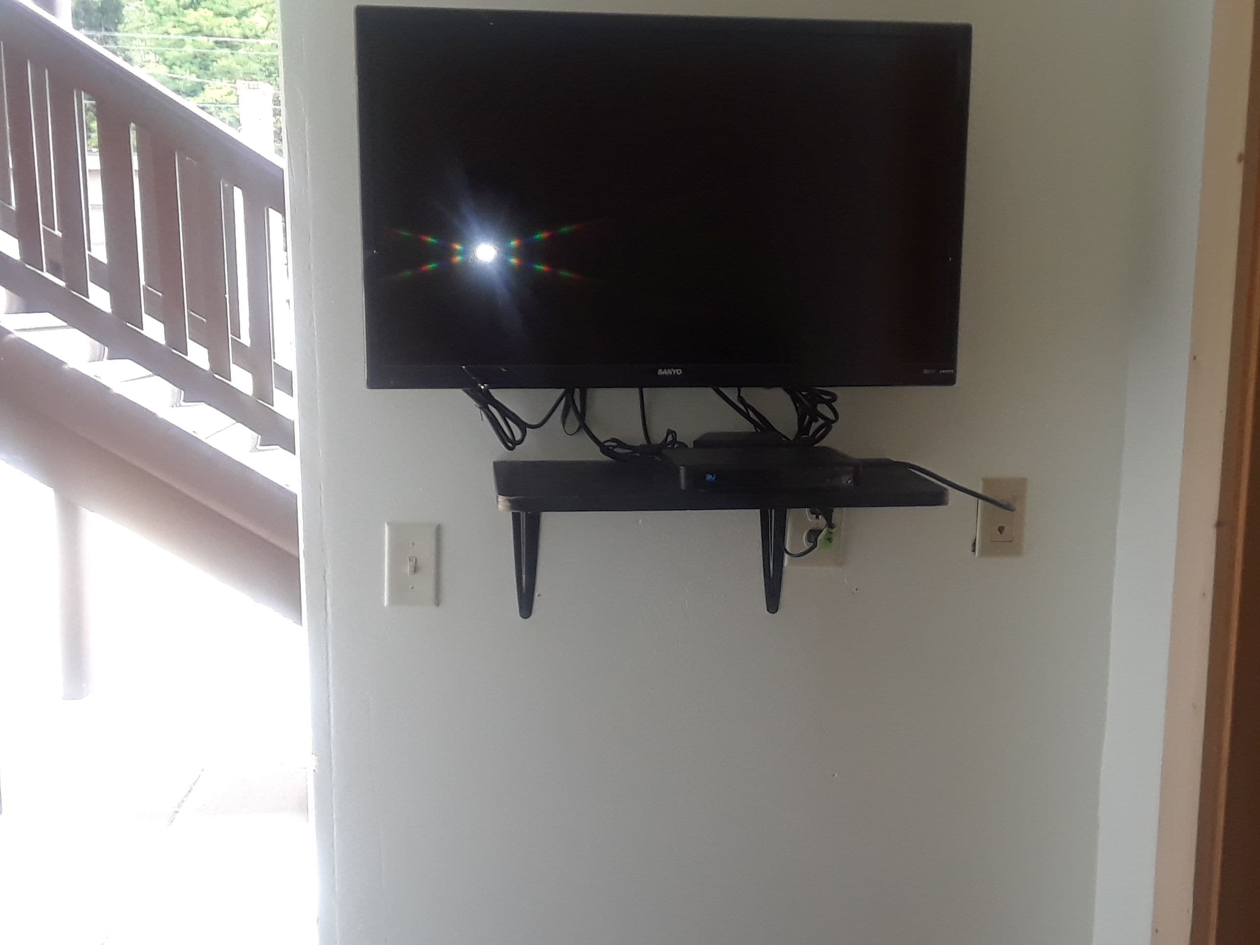 Una TV a schermo piatto montata a parete, con sistema di gestione dei cavi.