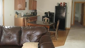 A living room with a brown leather couch and a dining table. - Mt. Baker Hotel (Concrete)