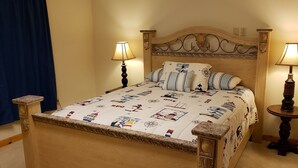 A bed with a nautical-themed bedspread, two bedside lamps, and a wooden headboard. - Mt. Baker Hotel (Concrete)