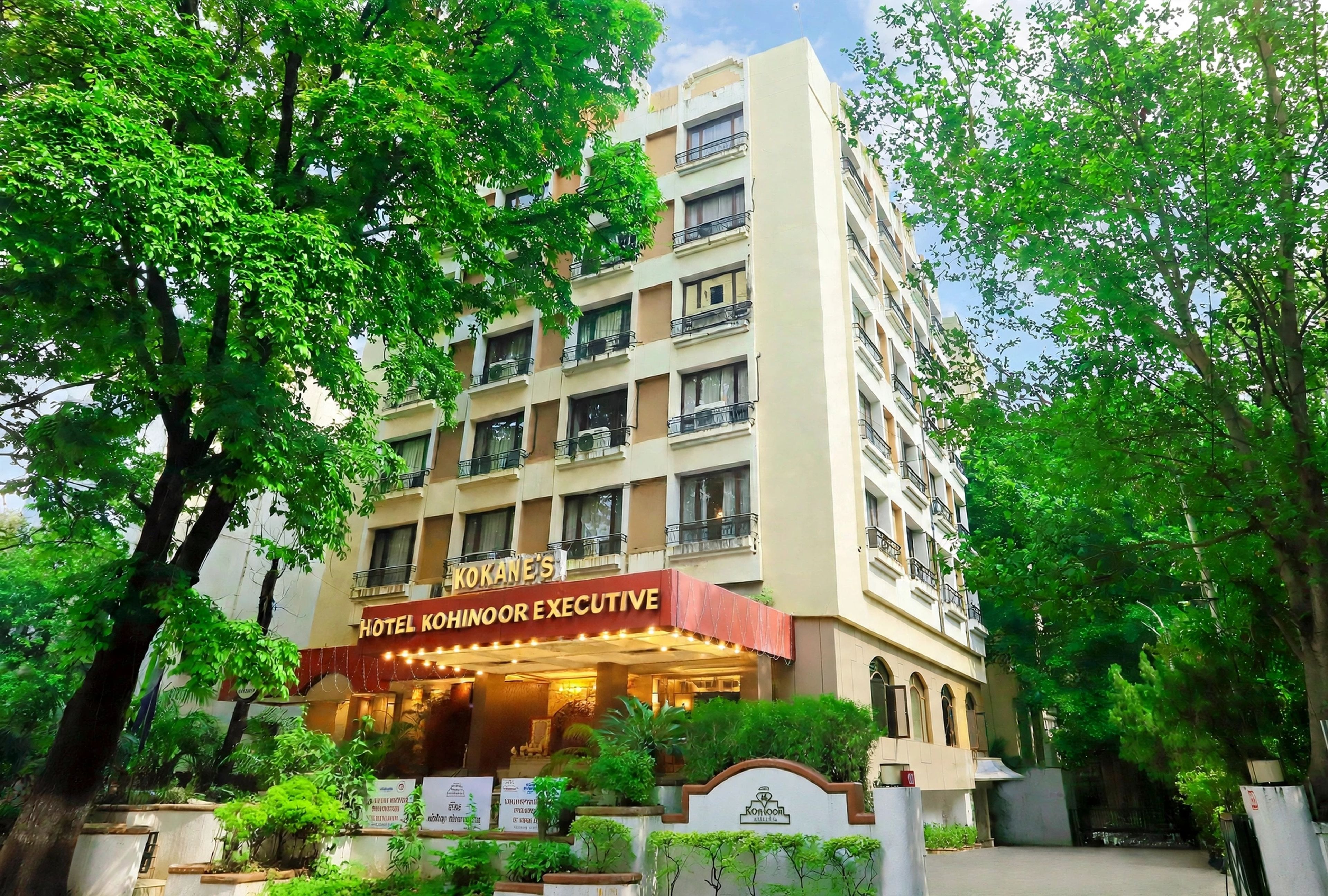 A multi-story hotel building with balconies and a sign indicating it is the 'Hotel Kokanoor Executive.'