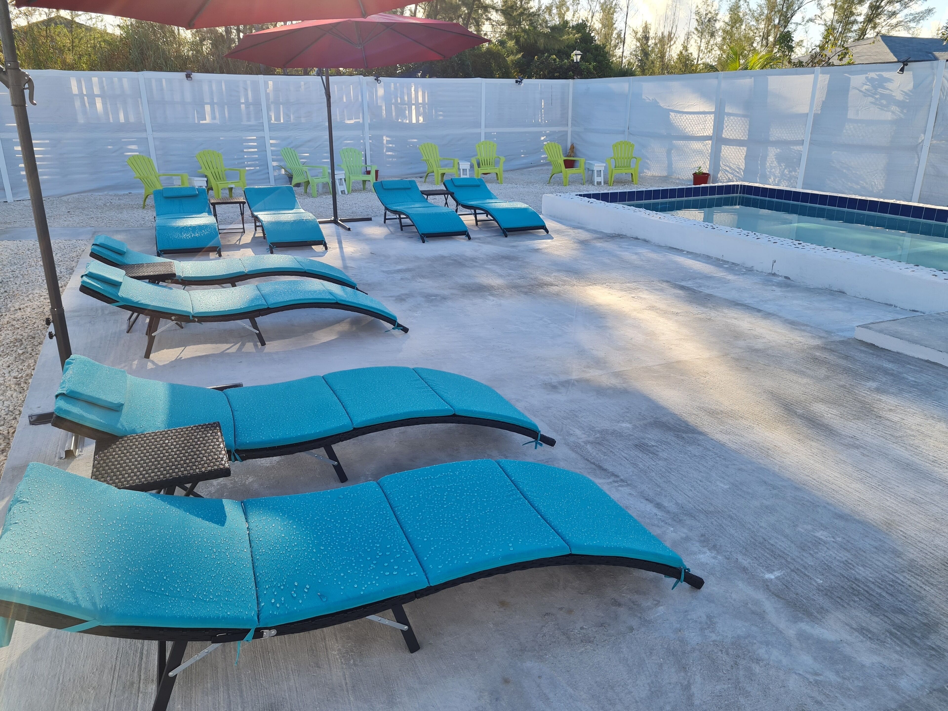 A poolside area with multiple lounge chairs and a small pool.