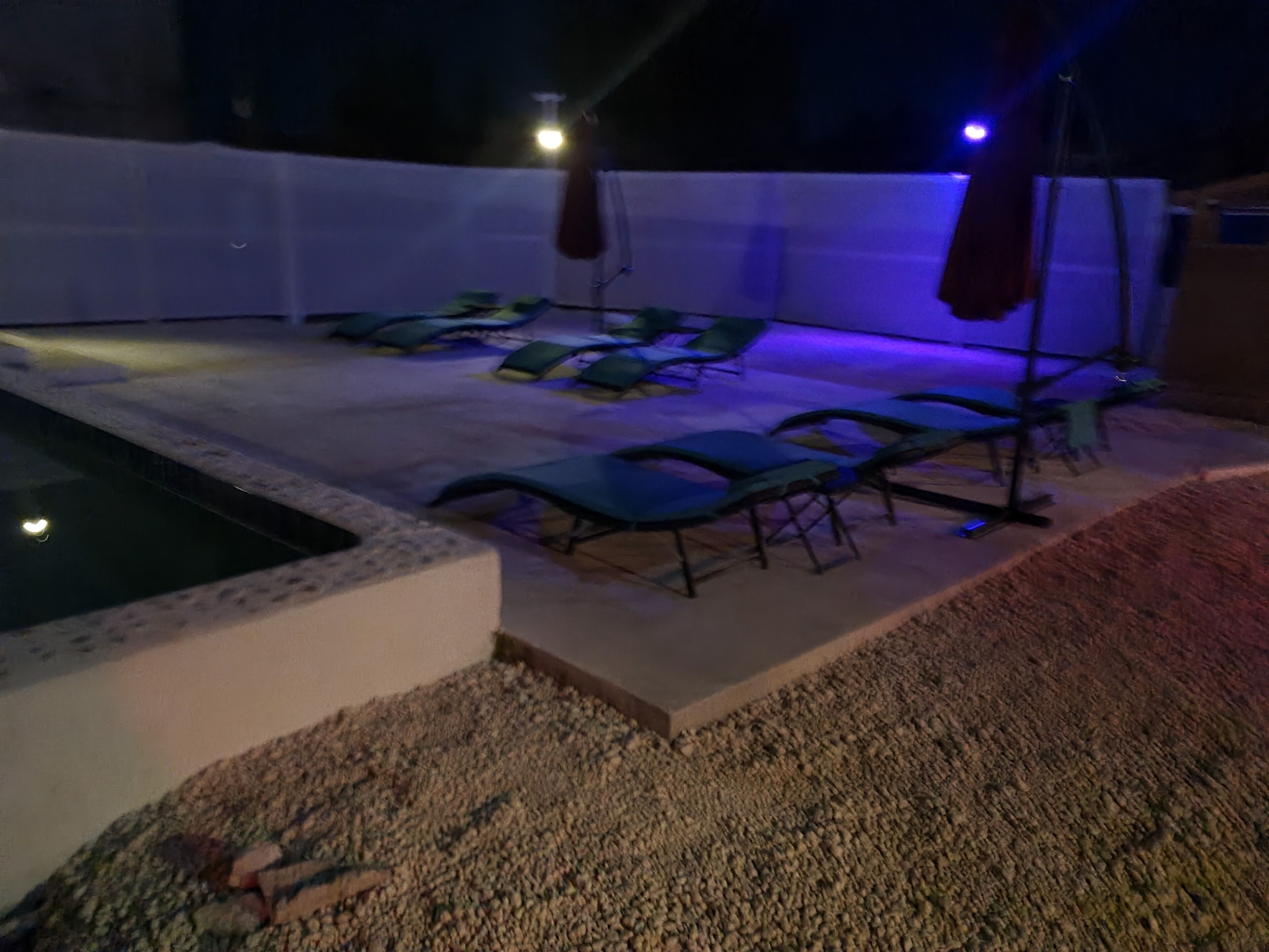 Un espace piscine avec des chaises longues et un jacuzzi.