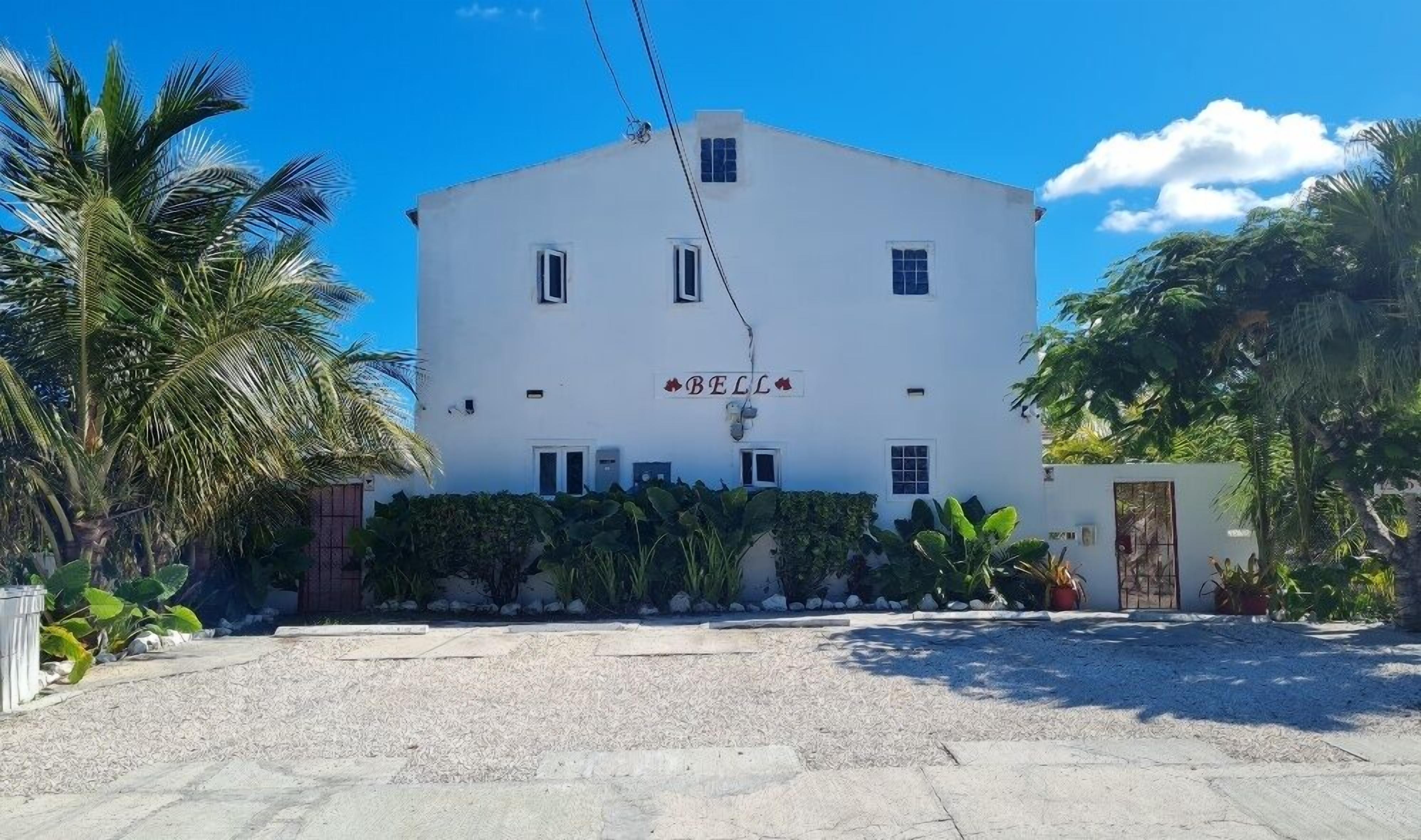 A white building with a sign reading "BELL" and a small balcony.