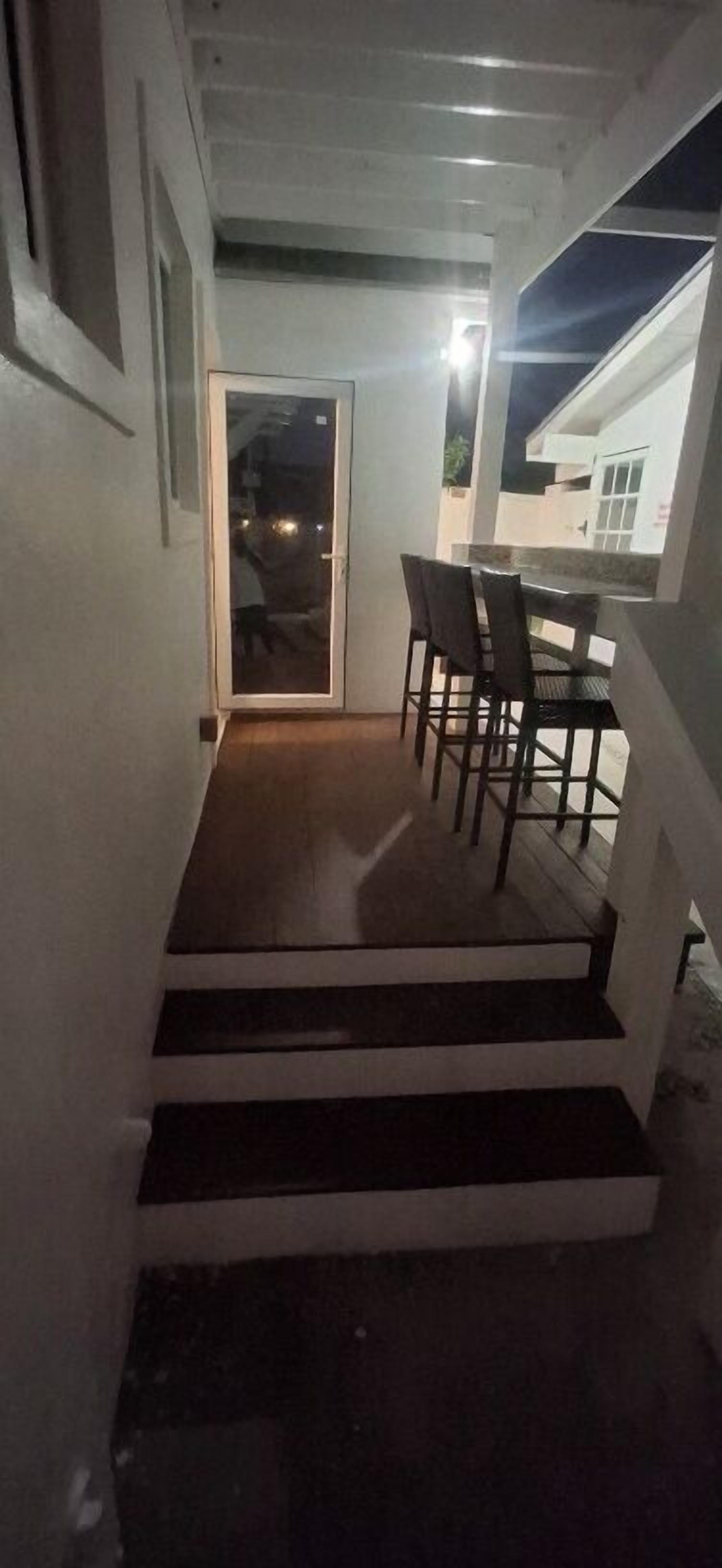 Una escalera que lleva a un balcón con una mesa y sillas.