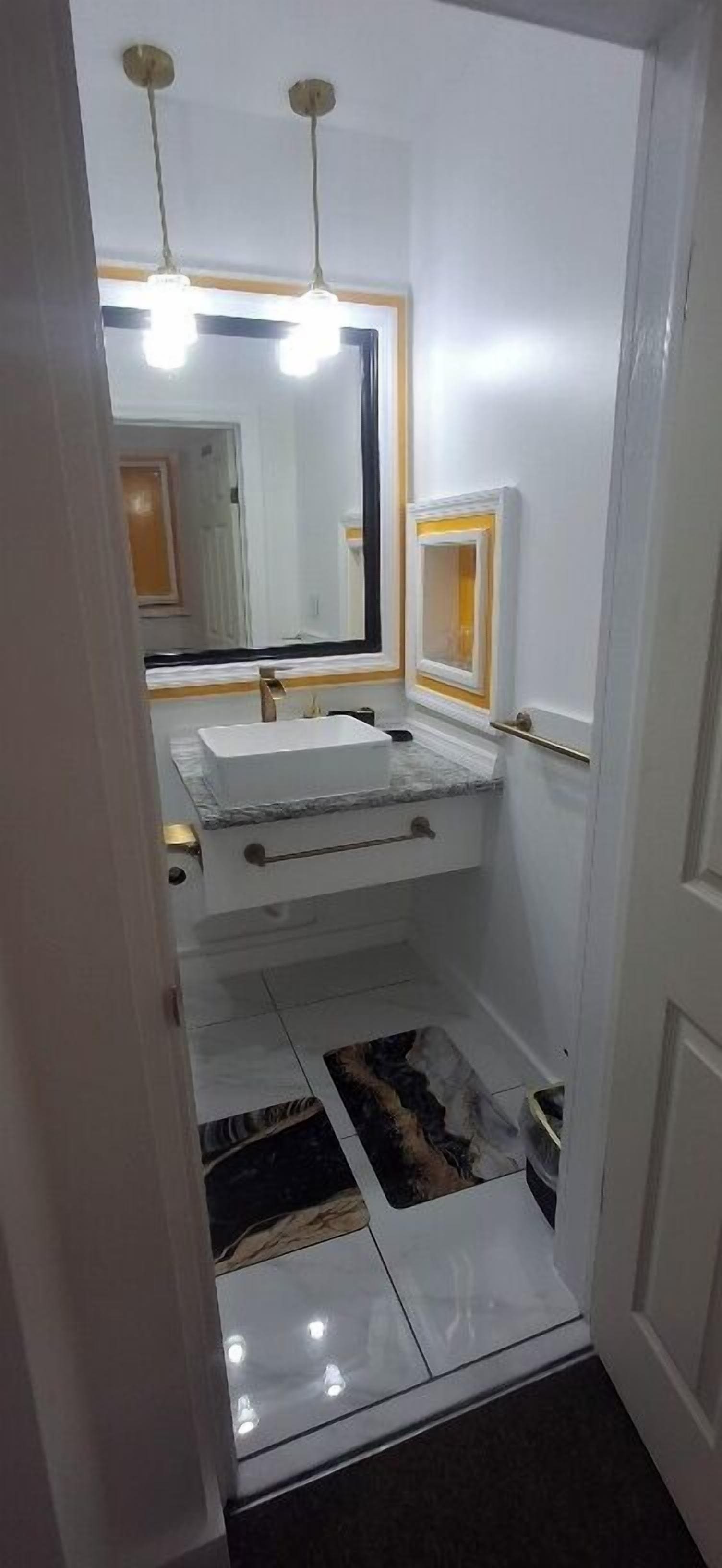 A bathroom with a white sink, mirror, and two pendant lights.
