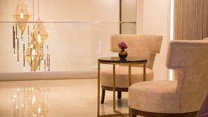 A modern interior with a glass partition, a round table with a vase, and two armchairs. - TN & CO Hotel (Mugla)