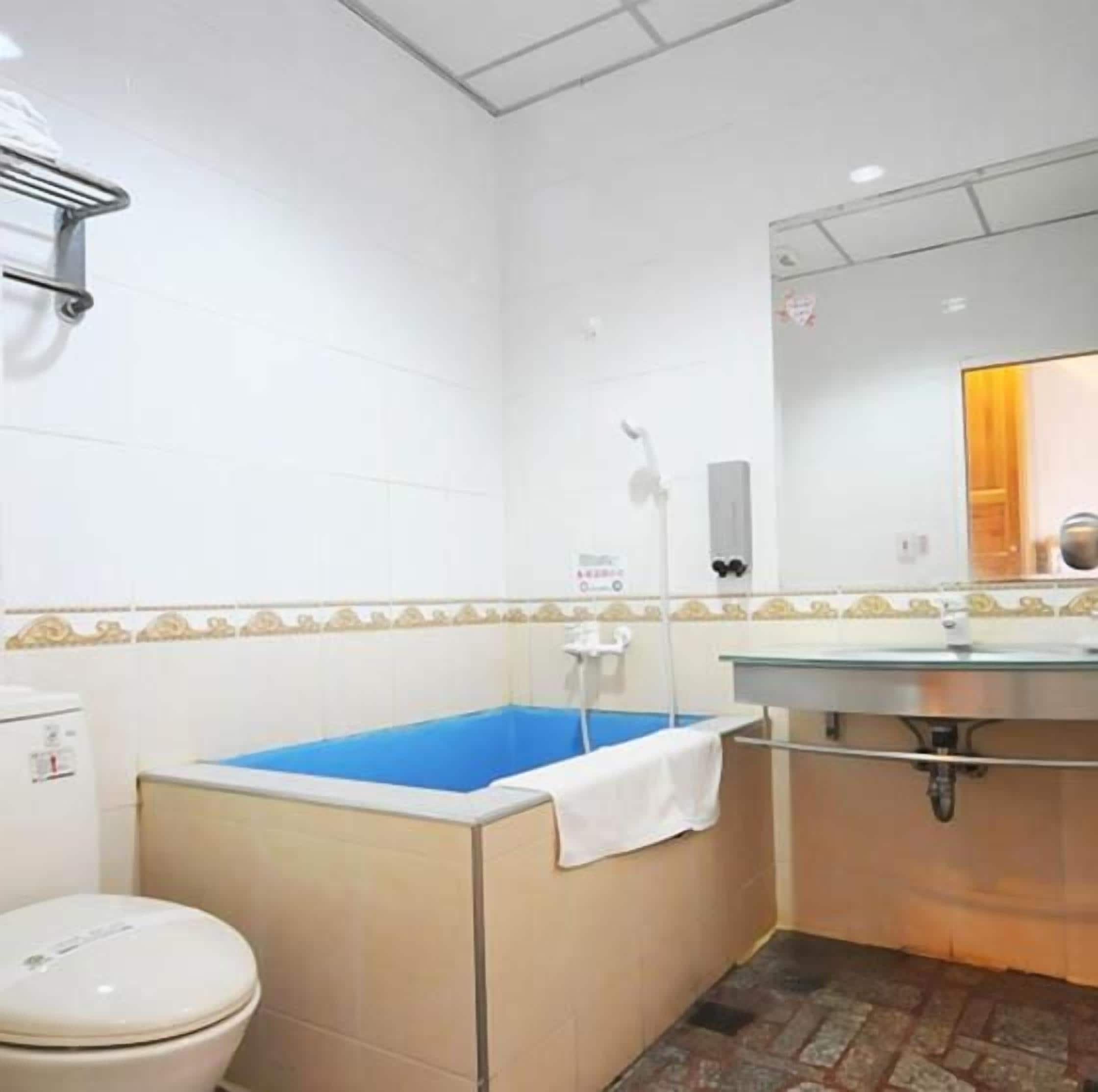 Un baño con inodoro, lavamanos y bañera.
