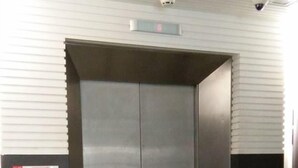 A modern elevator with metallic doors, a digital display, and a security camera above. - Hotel Hilal (Cyberjaya)