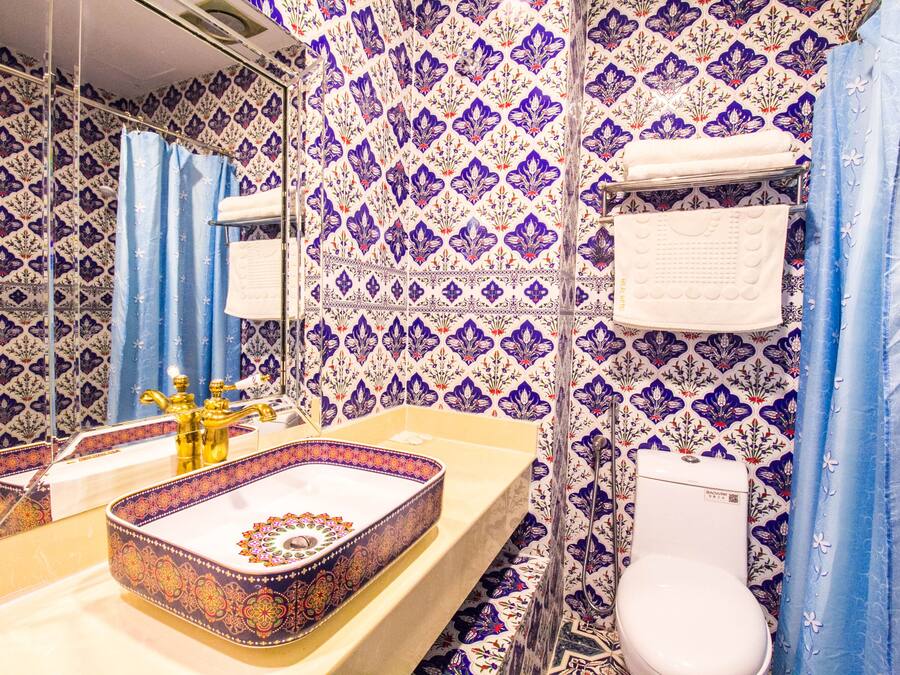 A bathroom with a sink, toilet, and shower curtain.