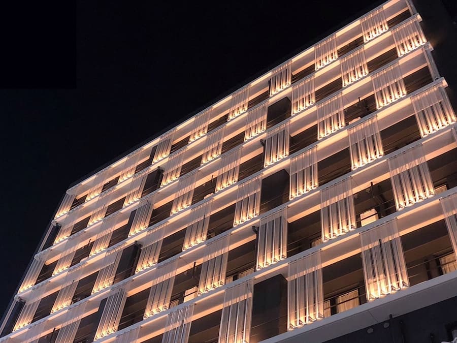 Un edificio a più piani con una serie di balconi illuminati da luci calde.