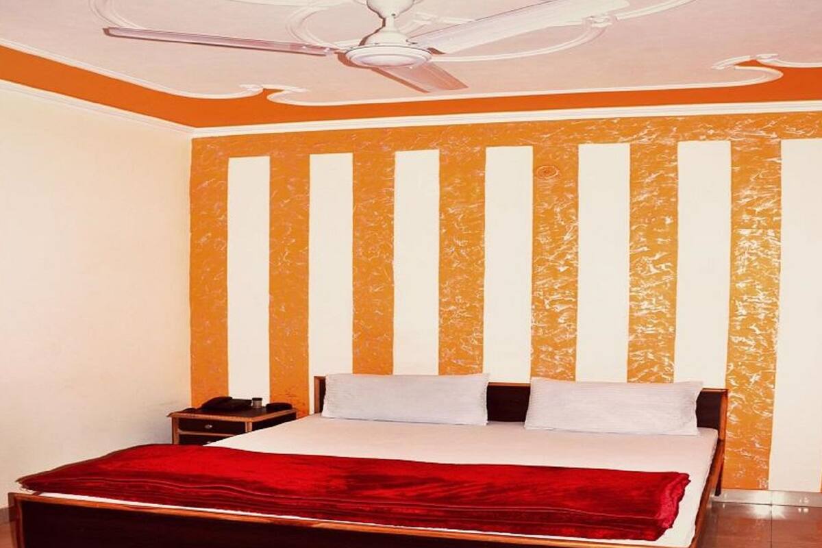 A bedroom with a bed, a nightstand, and a ceiling fan.