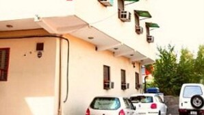 A building with a sign reading "Accent Hotel" and multiple balconies with green awnings. - Accent Hotel (Greater Noida)