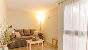 A cozy living room with a sofa, a small table, and a lamp.