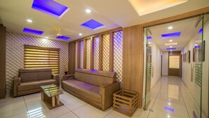 A modern living room with a sofa, a glass coffee table, and a ceiling fan. - Spring Field Billets (Kanayannur)