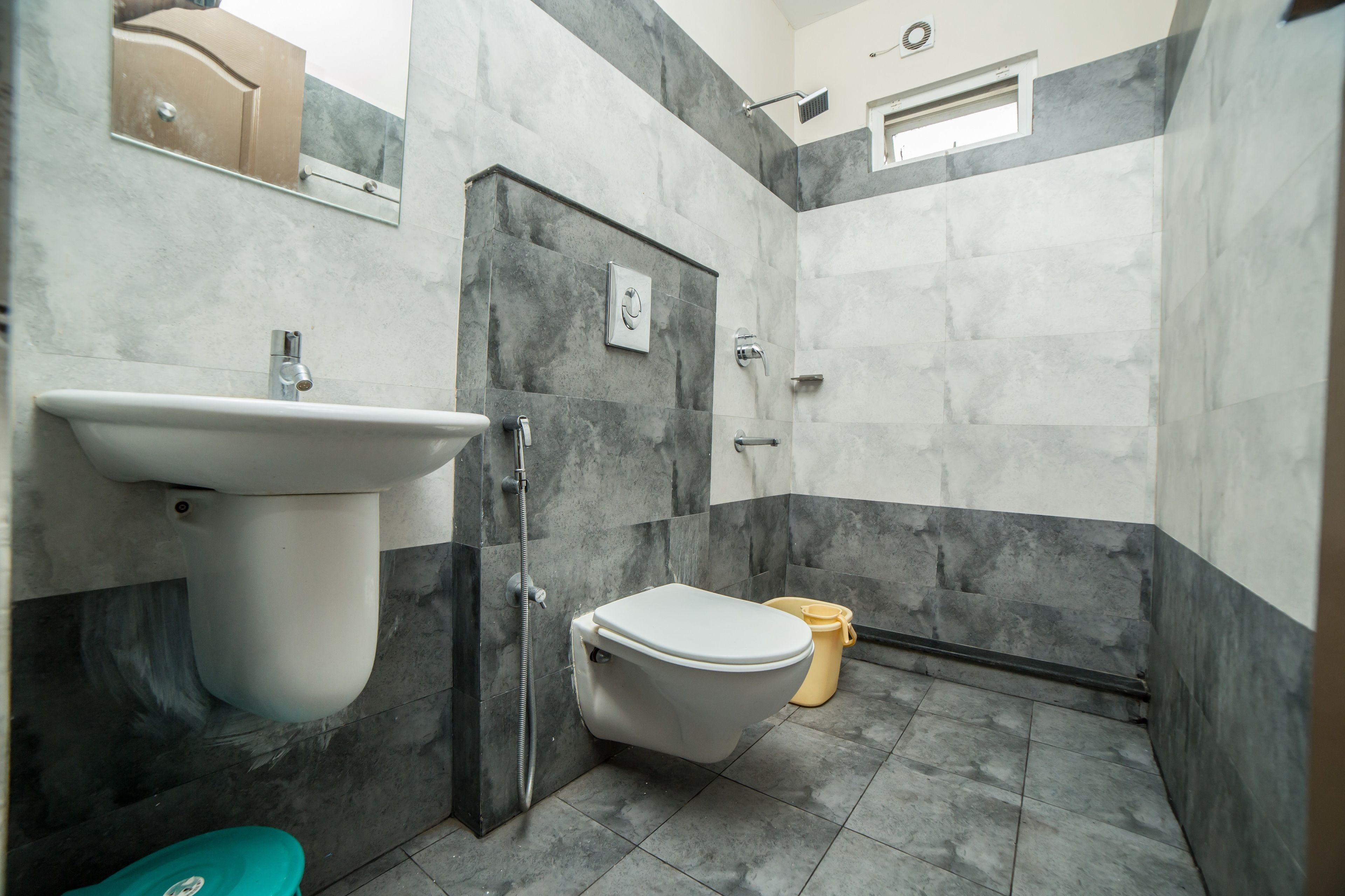 A bathroom with a toilet, sink, and shower.