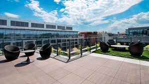 Una terrazza sul tetto con posti a sedere all'aperto e vista sullo skyline della città.