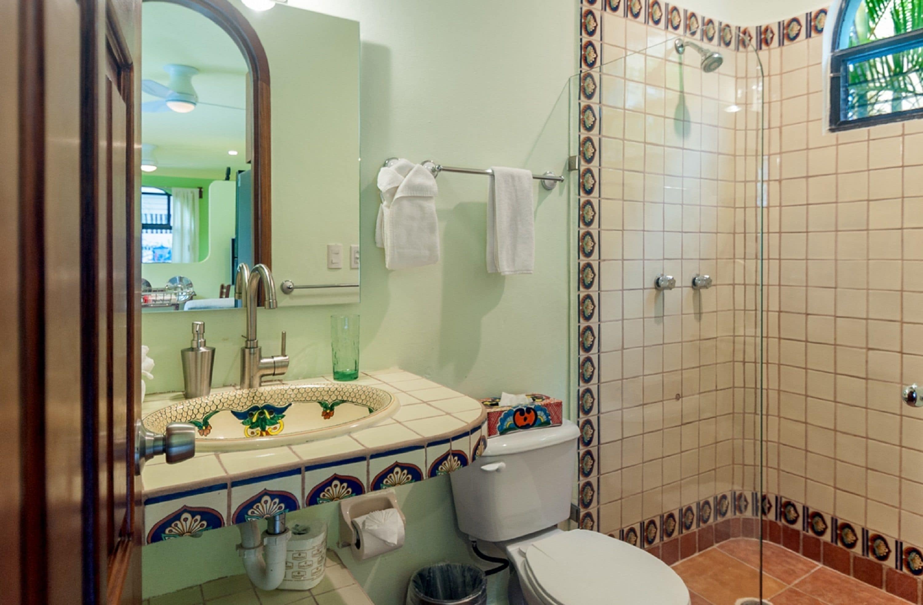 A bathroom with a sink, mirror, and shower.