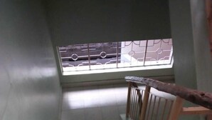 Una escalera con baldosas estampadas y barandilla de madera.