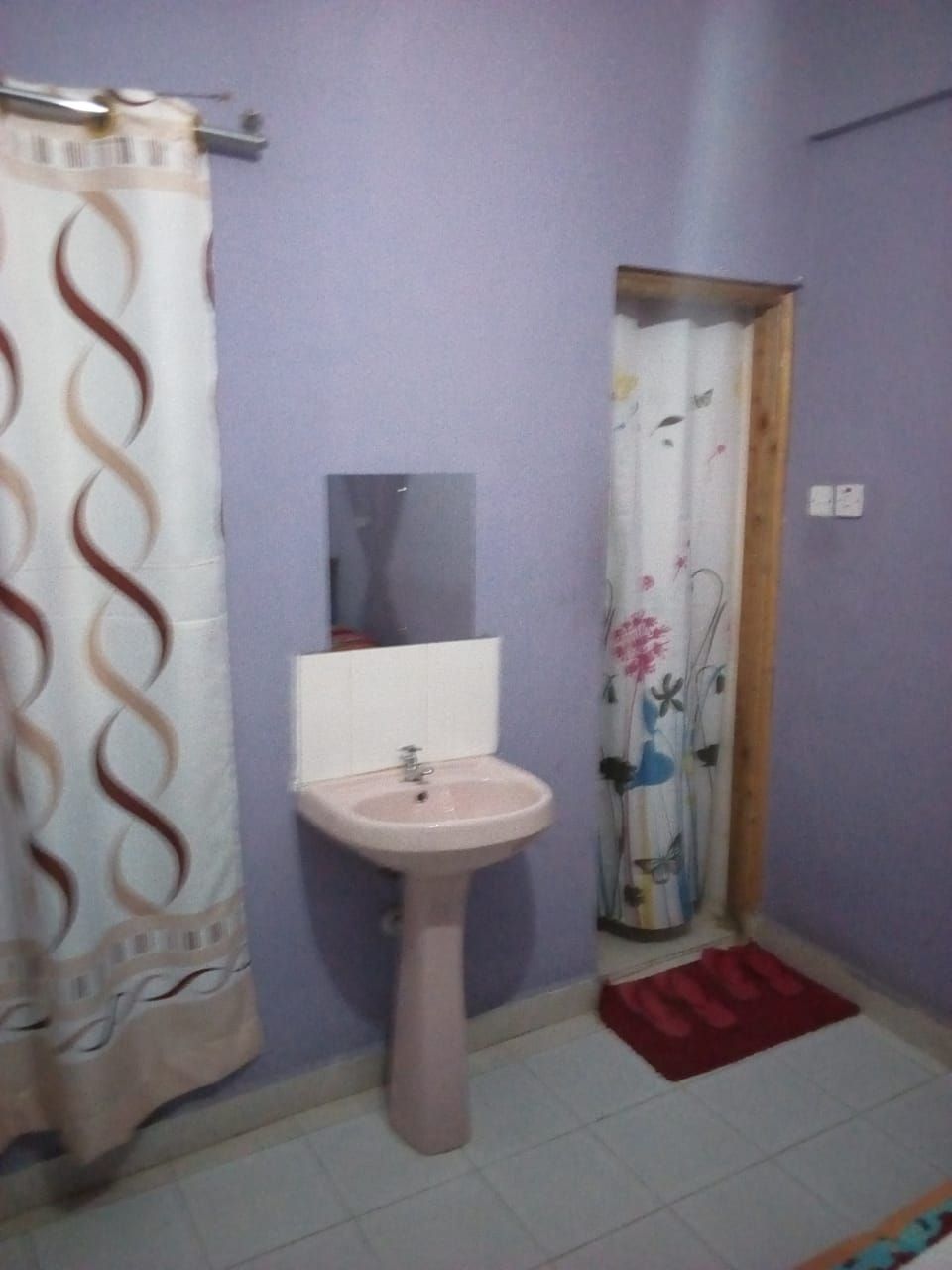 A bathroom with a sink, mirror, and shower curtain.