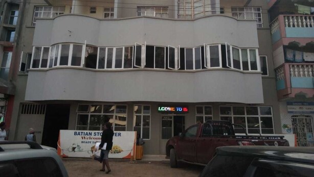 Un hotel con un cartel que dice "BATIAN HOTEL" y una entrada visible.
