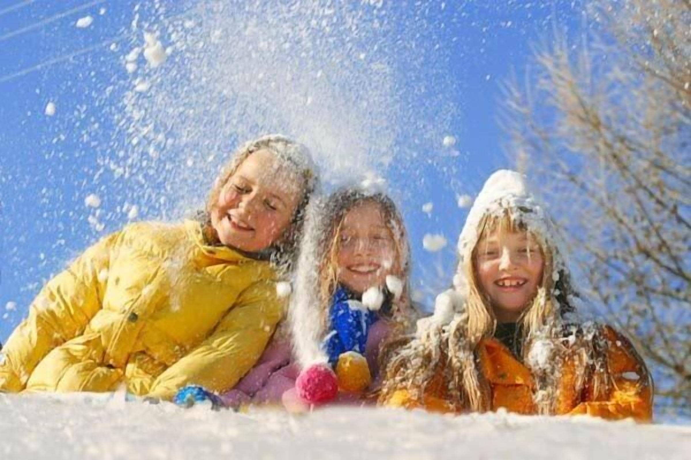 Three children playing in the snow.