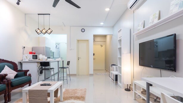 Un salon moderne comprenant un canapé, une table basse, un téléviseur et un coin repas avec une table et des chaises.