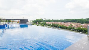 Une piscine avec vue sur un quartier résidentiel et un restaurant McDonald's en arrière-plan.