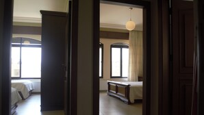 A hotel room with a bed, a bench, and a large window. - Sports City Jewel (Amman)