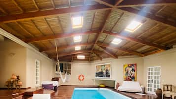 Una piscina techada, sillones reclinables de piscina