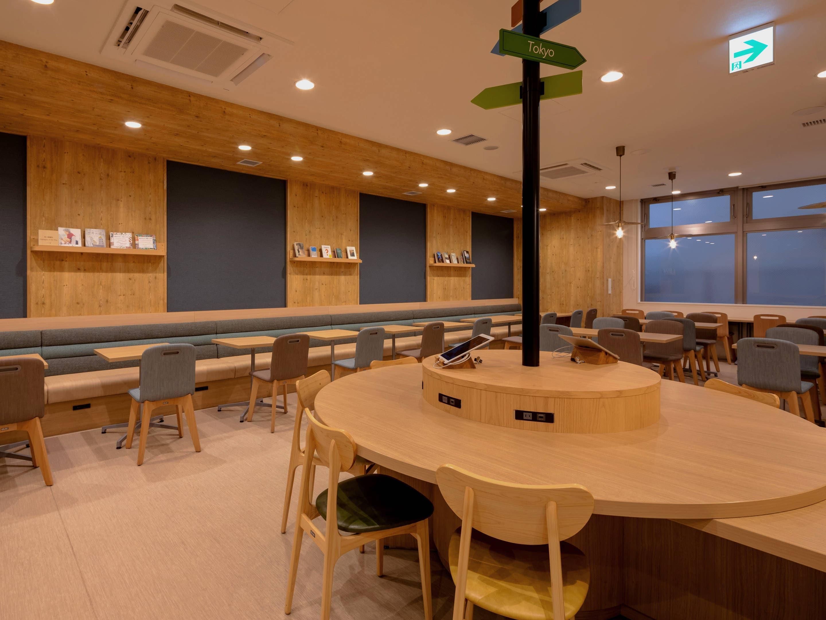 A modern interior with wooden panel walls, a central round table, and seating arrangements.