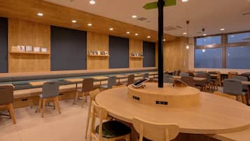 A modern interior with wooden panel walls, a central round table, and seating arrangements.
