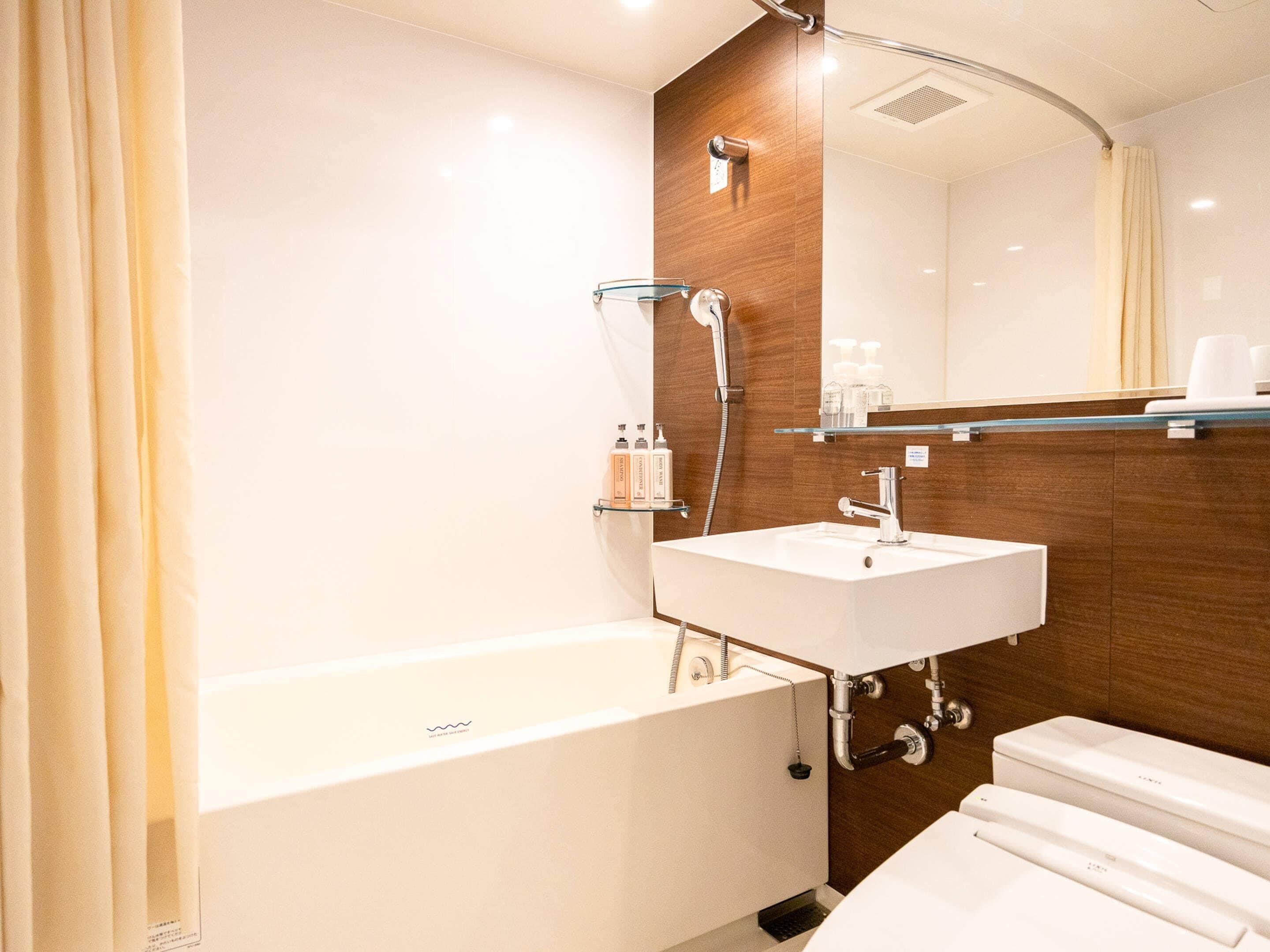 A modern bathroom with a bathtub, a sink, and a toilet.