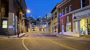 A street lined with historic buildings, some with storefronts, under a twilight sky.