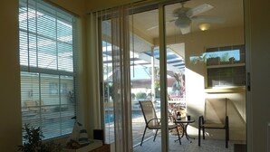 A room with a sliding glass door leading to an outdoor patio with chairs and a table. - Sun, beach, and great savings –discover amazing discounts on dream destinations! (Cape Coral)