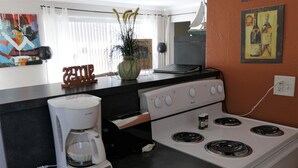 A kitchen with a white stove, a coffee maker, and a vase with plants. - Sun, beach, and great savings –discover amazing discounts on dream destinations! (Cape Coral)
