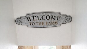 Una escalera lleva a una puerta con un cartel que dice 'Welcome to the Farm'.