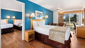 A hotel room with two beds, a desk, a chair, and a view of the outdoors. - Skylark Shores Resort (Lakeport)
