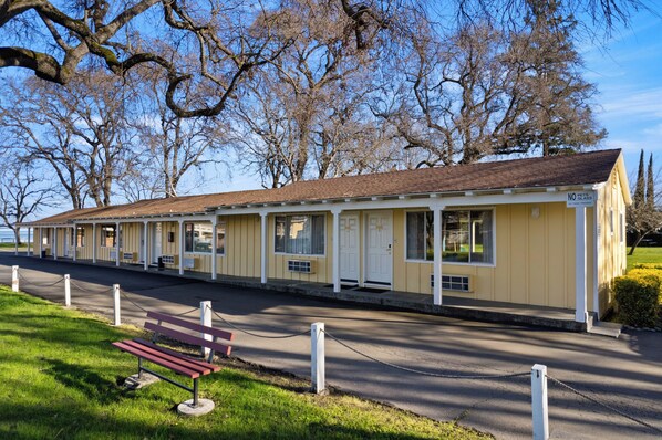 A row of yellow motel rooms with white trim and a 'No Pets Allowed' sign. - Skylark Shores Resort (Lakeport)